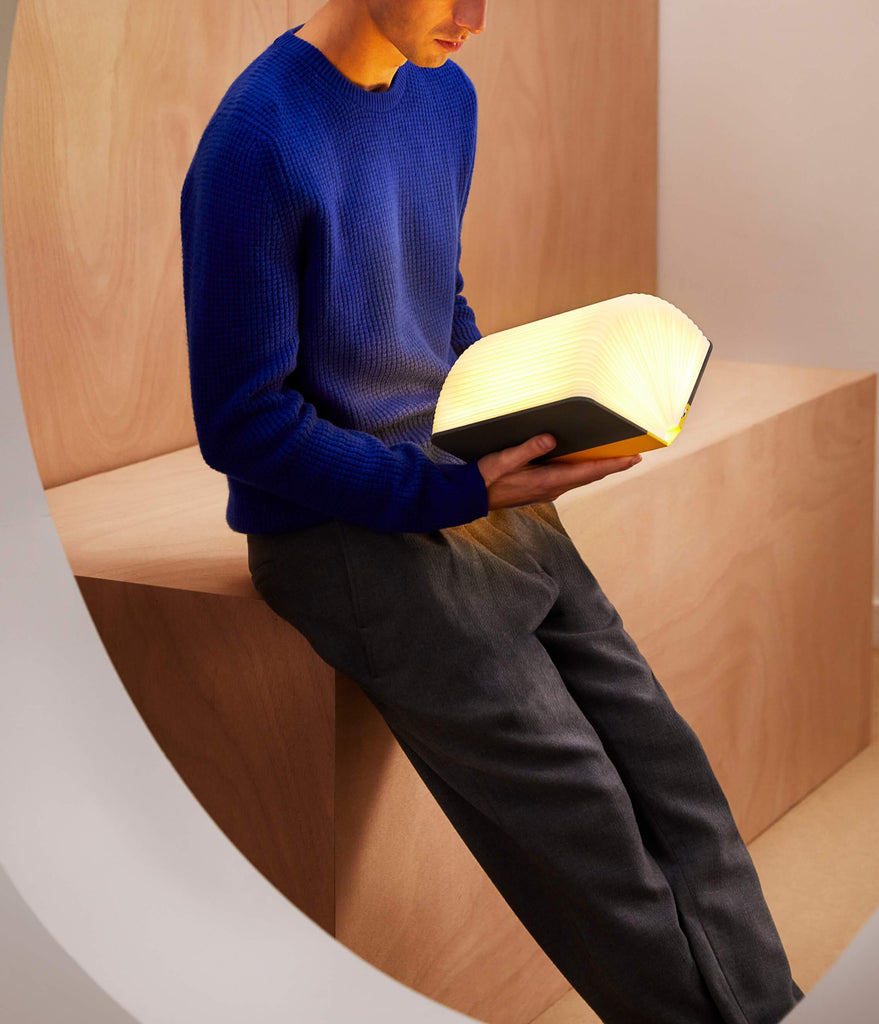 Male model holding Lumio Lito booklamp