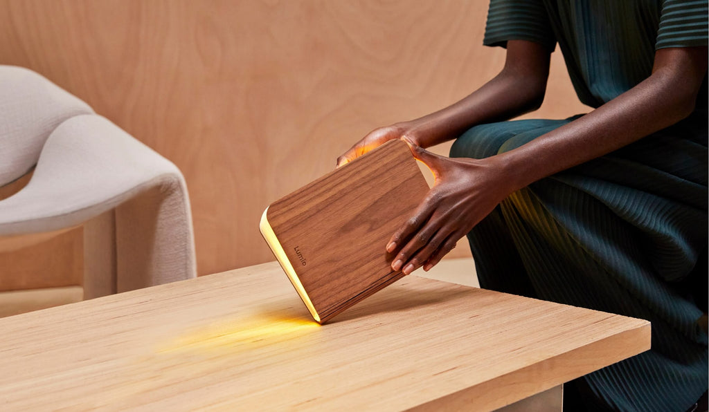Female model holding Lumio Lito walnut booklamp