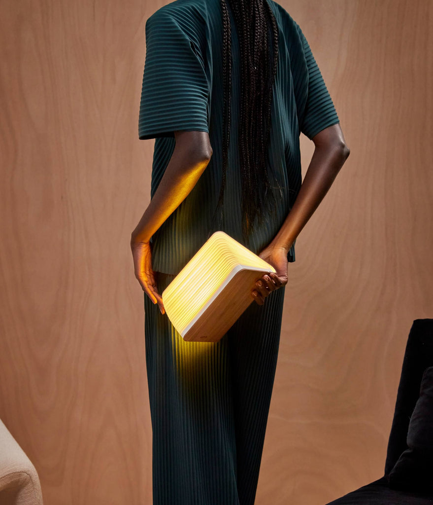 Female model holding Lumio Lito walnut booklamp